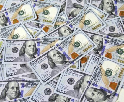 Pile of US hundred dollar bills depicting financial success and wealth.